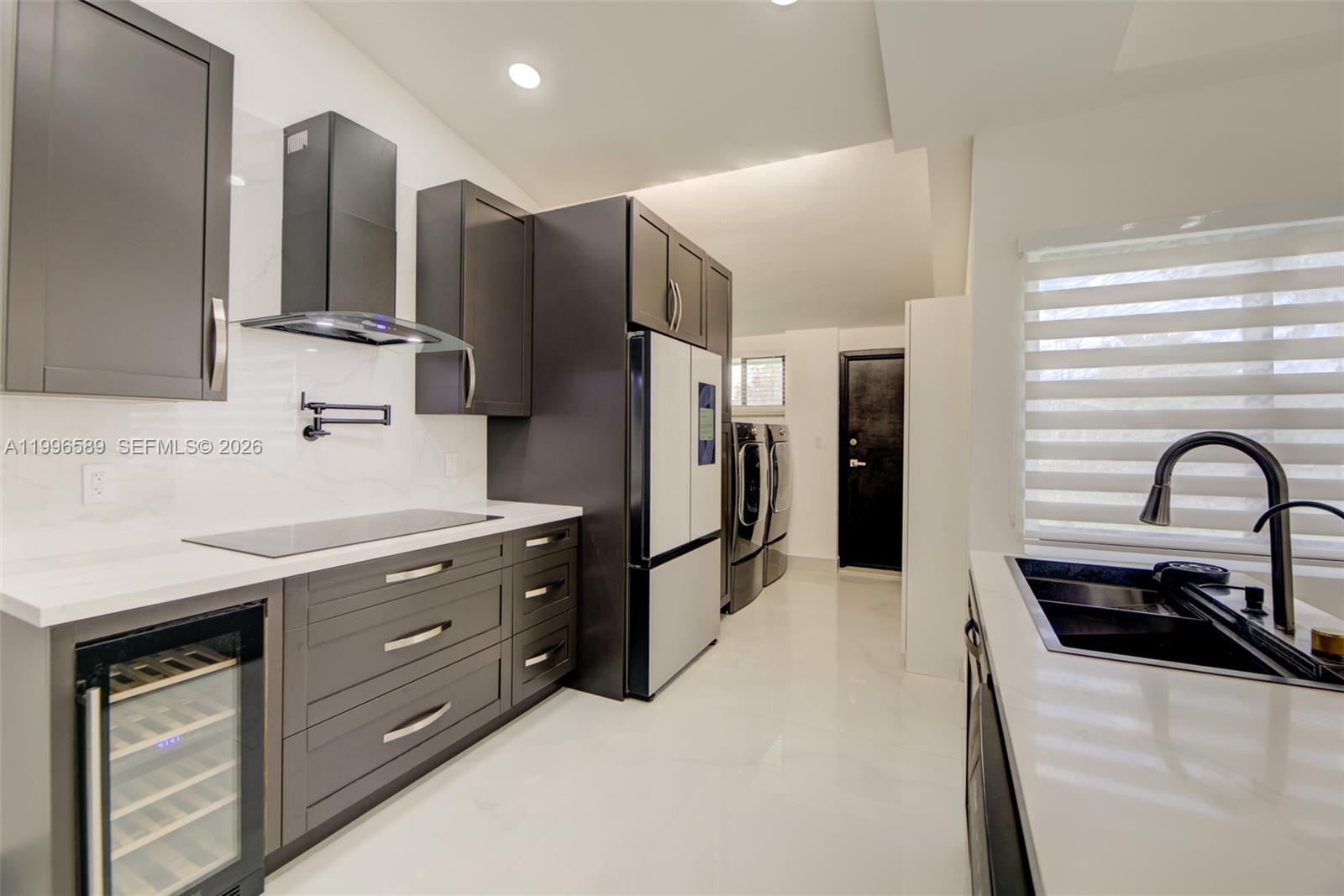 17101 Southwest 48th Street Southwest Ranches, FL 33331 - Photo 10 of 31 a kitchen with stainless steel appliances a sink cabinets and a counter top space