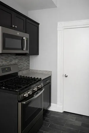 a kitchen with stainless steel appliances a stove a microwave a sink and cabinets