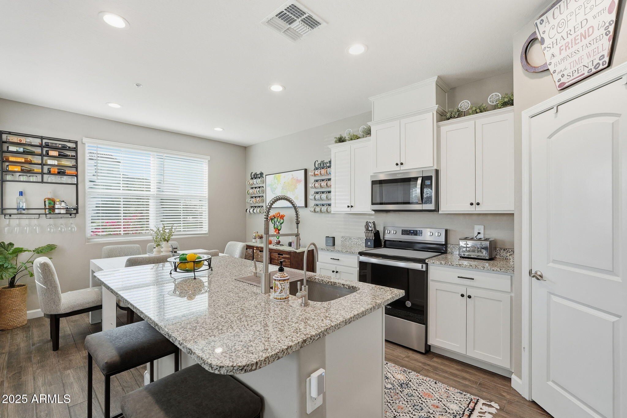 1255 North Arizona Avenue, Unit 1323 Chandler, AZ 85225 - Photo 11 of 30 a kitchen with stainless steel appliances granite countertop a stove a sink a microwave a dining table and chairs