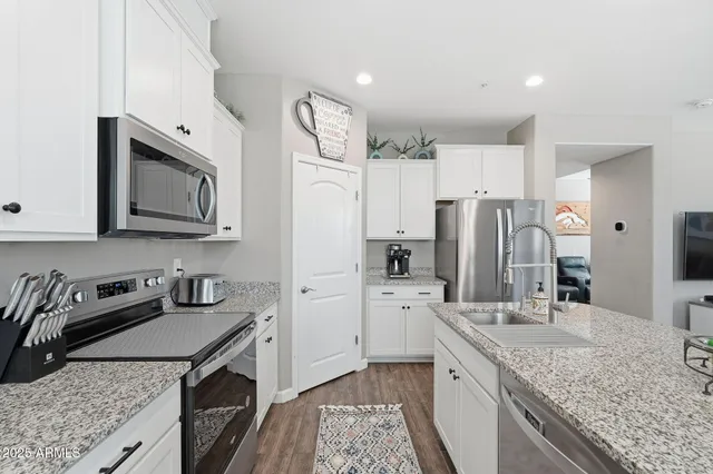 a kitchen with stainless steel appliances granite countertop a sink stove and refrigerator