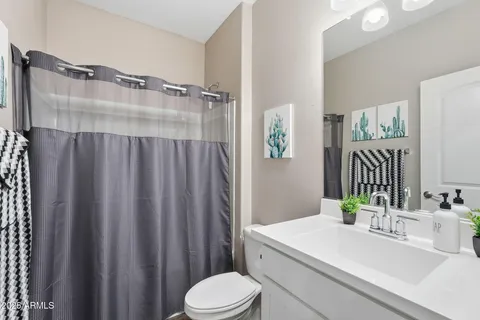 a bathroom with a sink vanity mirror and toilet