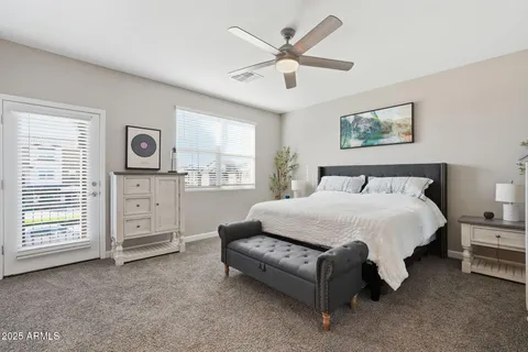 a spacious bedroom with a bed a dresser and a window