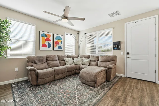a living room with furniture ceiling fan and a window