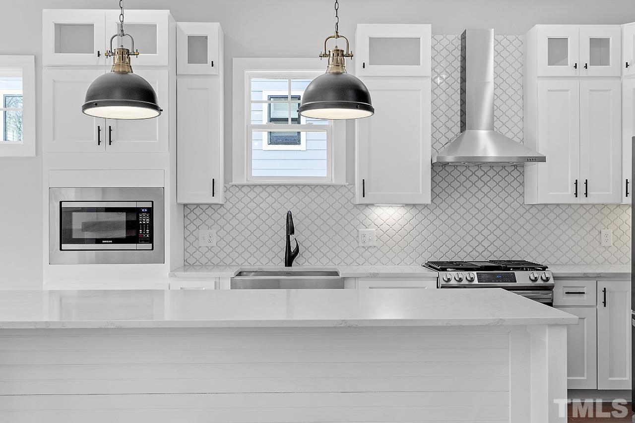 2320.5 Milburnie Road Raleigh, NC 27610 - Photo 20 of 32 a kitchen with a stove and a white cabinets
