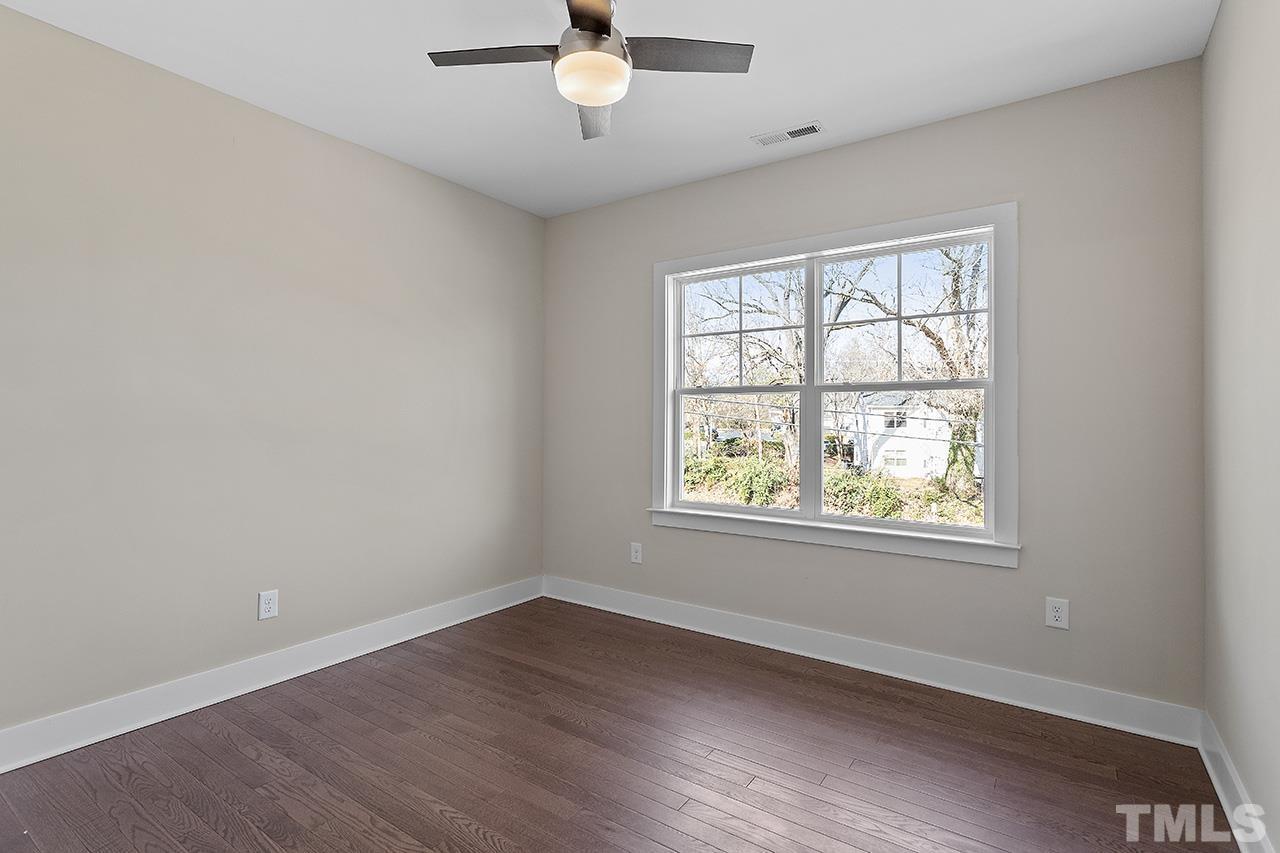 2320.5 Milburnie Road Raleigh, NC 27610 - Photo 28 of 32 an empty room with wooden floor and windows