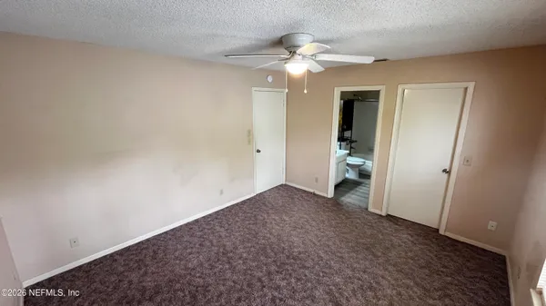 an empty room with chandelier fan