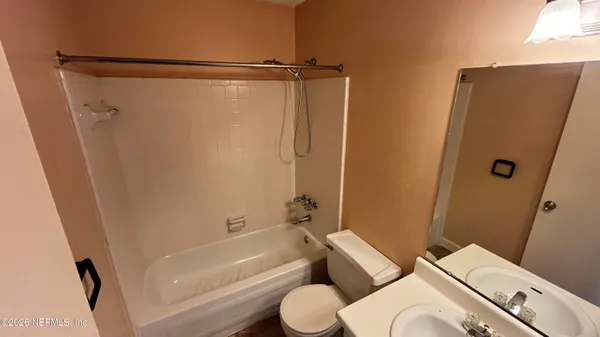 a white toilet sitting next to a bath tub