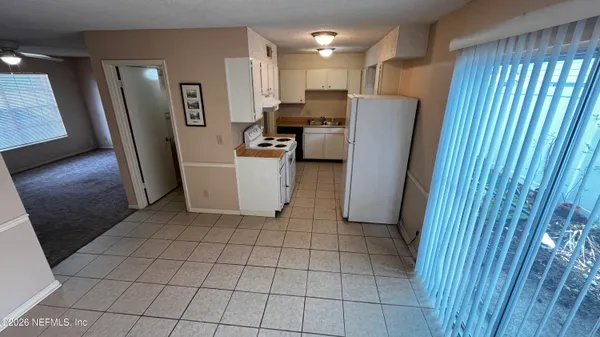 a view of kitchen with refrigerator and window