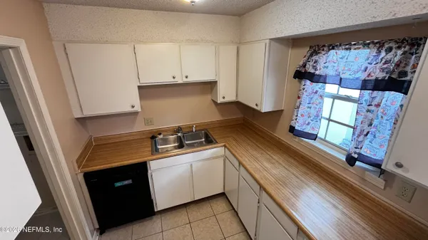 a kitchen with a sink a stove top oven and cabinets