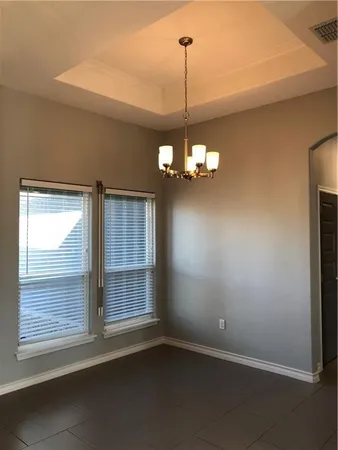 a view of a livingroom with a chandelier fan and windows