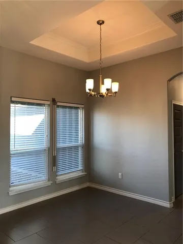 a view of a livingroom with a chandelier fan and windows