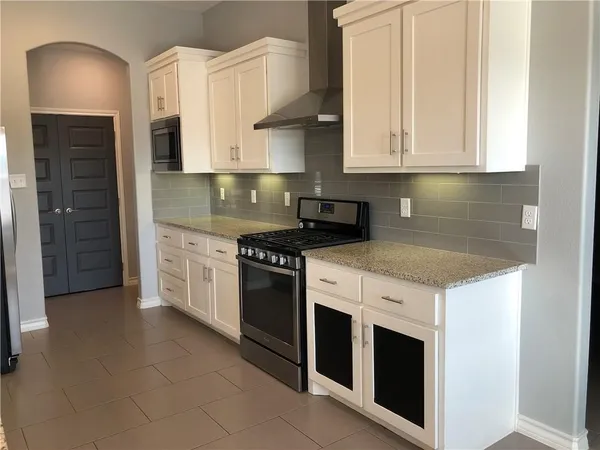 a kitchen with stainless steel appliances granite countertop a stove a sink and a refrigerator