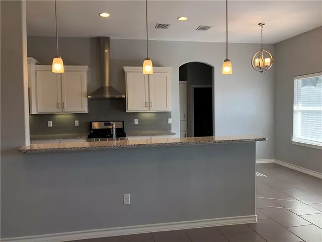 a view of kitchen with kitchen island stainless steel appliances wooden floor and window