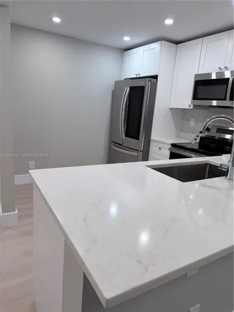 a kitchen with a sink a microwave and refrigerator