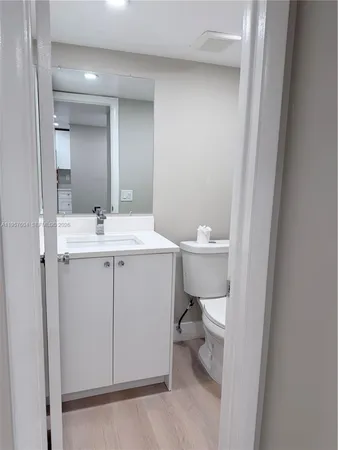 a bathroom with a sink a toilet and a mirror