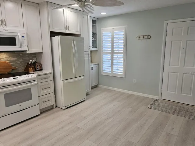 a kitchen with a refrigerator stove and white cabinets