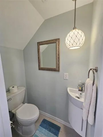 a bathroom with a toilet a sink and mirror