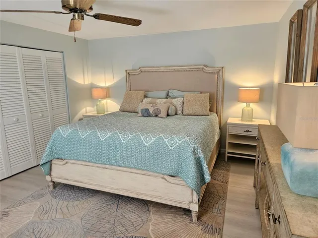 a bed sitting in a bedroom next to a lamp and a chandelier