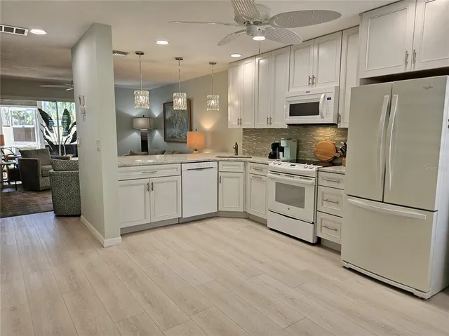 a kitchen with white cabinets and white appliances