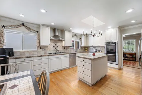a kitchen with stainless steel appliances granite countertop a refrigerator a oven and a sink