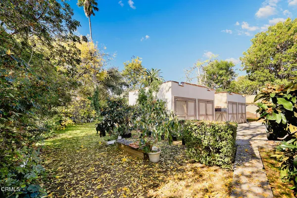 a patio with table and chairs and potted plants