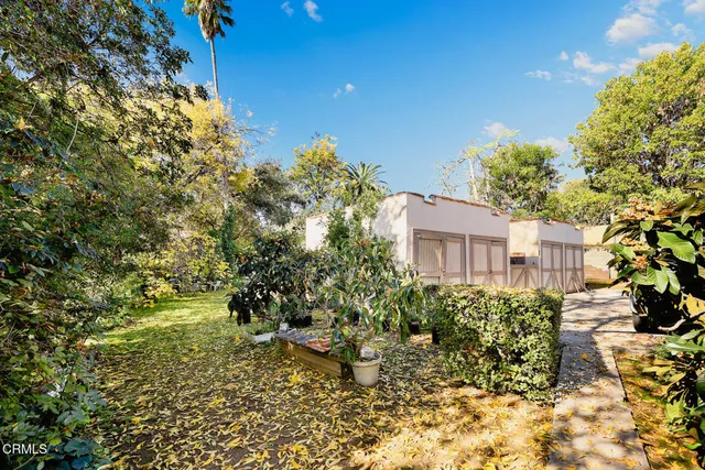 a patio with table and chairs and potted plants
