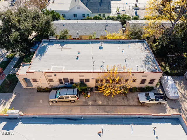 an aerial view of residential houses with outdoor space and swimming pool