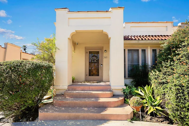 a view of a house with potted plants