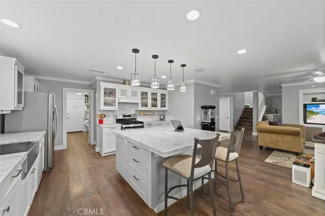a large kitchen with stainless steel appliances granite countertop a lot of counter space and wooden floor