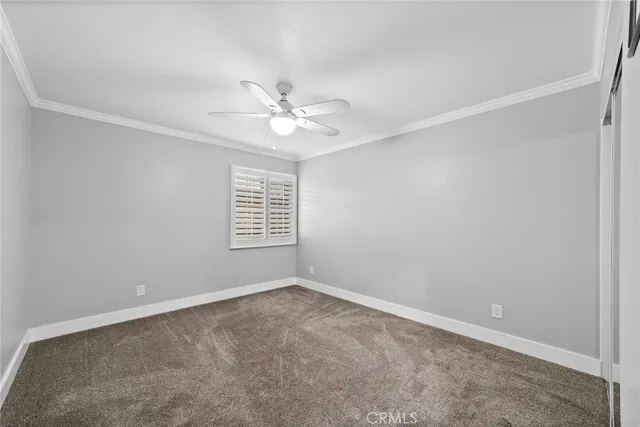 an empty room with a window and a ceiling fan