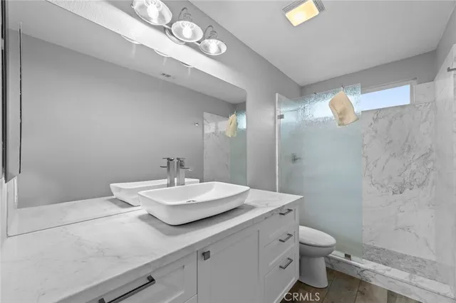 a bathroom with a sink a toilet and mirror