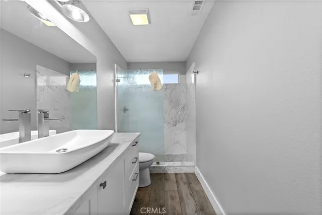 a bathroom with a sink a toilet and shower