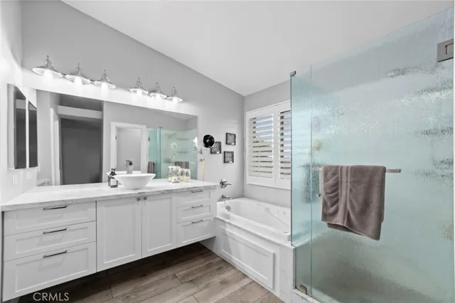a bathroom with a double vanity sink mirror and bathtub