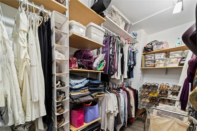 a view of walk in closet with clothes and shoes
