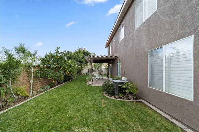 a view of a chair and table in backyard of the house