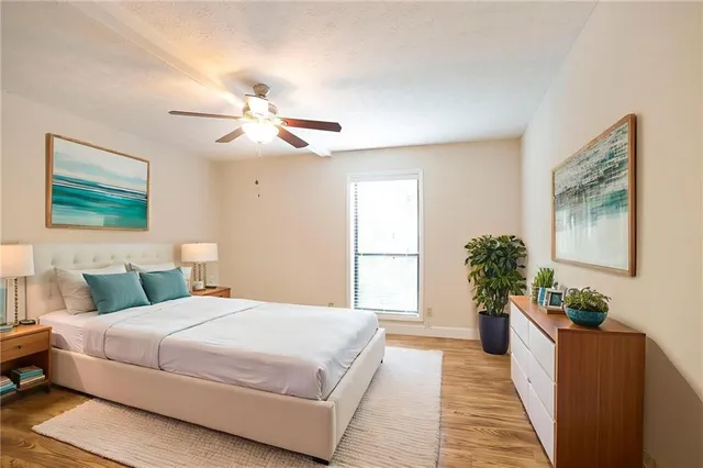 a bedroom with a large bed chandelier and a window