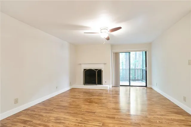 a view of an empty room with a fireplace and a window
