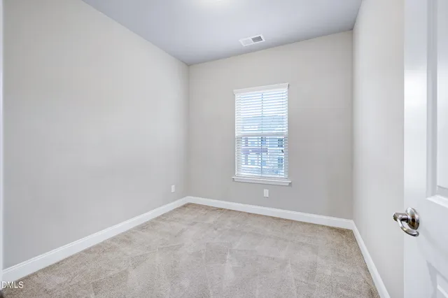 an empty room with closet and a bathroom