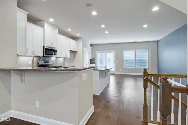 a kitchen with stainless steel appliances granite countertop a stove a sink and a refrigerator