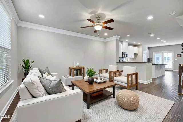 a living room with furniture and a view of kitchen