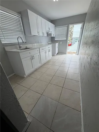 a kitchen with a sink a cabinets and window