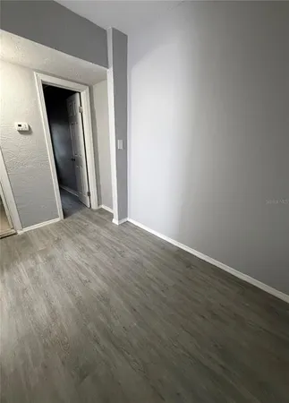 an empty room with wooden floor and closet