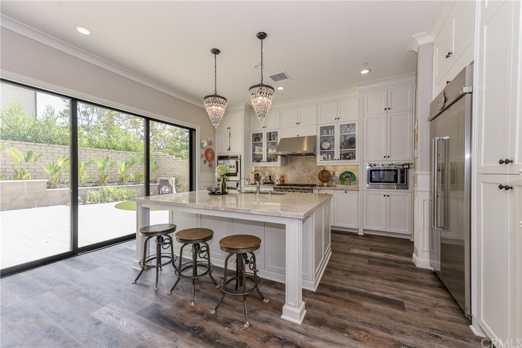 18 Tomango Lake Forest, CA 92630 - Photo 7 of 45 a kitchen with stainless steel appliances granite countertop a table chairs and a chandelier