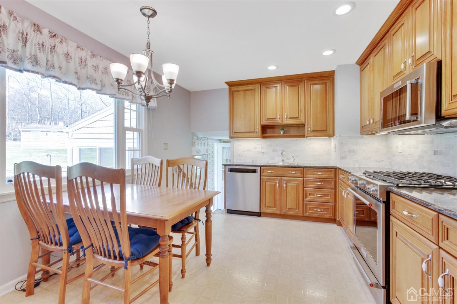 975 Carteret Road Bridgewater, NJ 08807 - Photo 7 of 25 a kitchen with stainless steel appliances granite countertop a stove top oven a sink a dining table and chairs