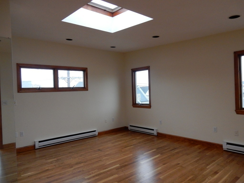63 Bucknam Street Everett, MA 02149 - Photo 20 of 28 a view of an empty room with wooden floor and a window