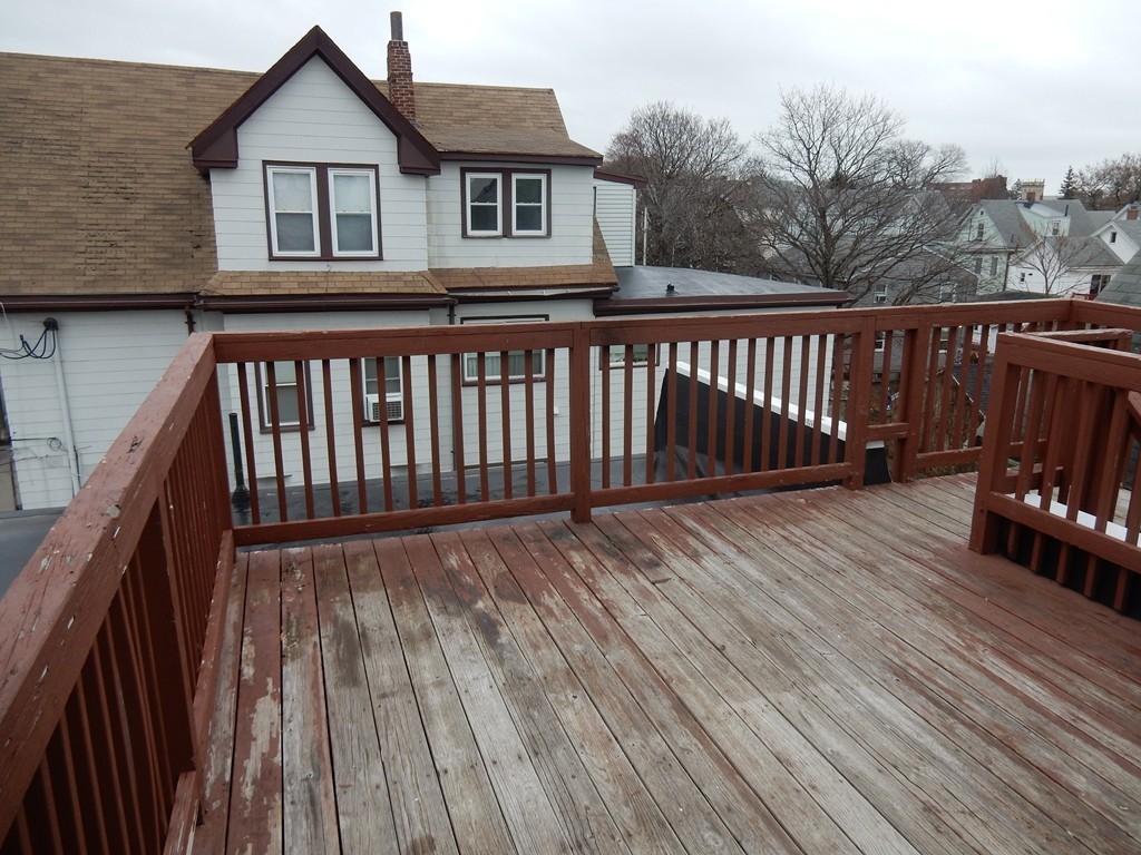 63 Bucknam Street Everett, MA 02149 - Photo 22 of 28 a balcony with wooden floor table and chairs