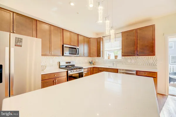a kitchen with stainless steel appliances a refrigerator sink and microwave