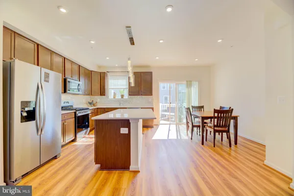 a kitchen with stainless steel appliances wooden floors and wooden cabinets
