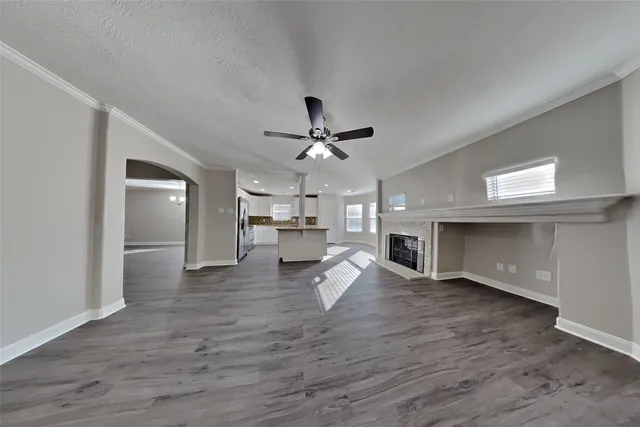 a living room with kitchen view and wooden floor