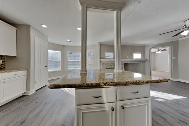 a bathroom with a granite countertop sink and white cabinets